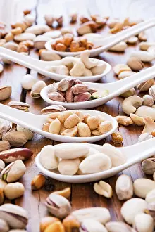 Deserted Table Scene Prints: Mix of nuts over a rustic table in backlit