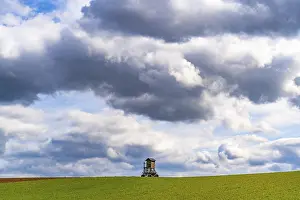 Deserted Farmland Germany Prints: Mobile raised hide in an empty field under dramatic clouds