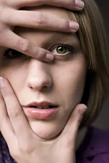 Blond Woman Looking At Camera Prints: Model posing her hands around her face