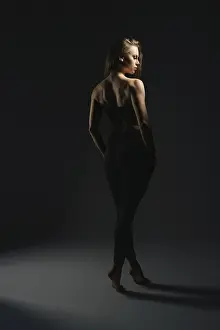 Elegant Woman Portrait Prints: A model stands elegantly under soft lighting in a dark studio