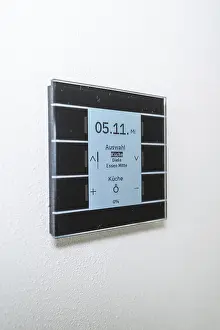 Minimalism In Interior Design Prints: A modern switch on the wall with a blue display