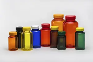 Pharmaceutical Packaging Solutions Prints: Multi colored transparent plastic pill jars on a white background
