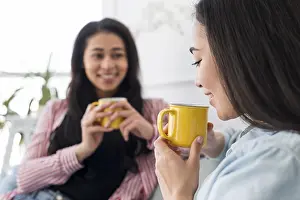 Christmas Season Prints: Multiethnic girlfriends talking drinking tea