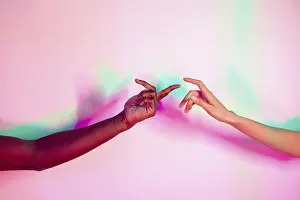 Peaceful Teamwork Image Prints: Two multiethnic hands extend toward each other against a vibrant