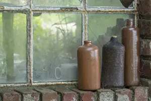Ceramic Decorative Items Prints: Three old earthenware bottles in front of a stable window