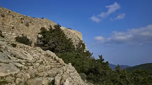 Historic Greek Castles Prints: An old stone wall surrounded by steps and trees