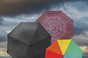 Deserted Cloudscape Prints: Open umbrellas with storm gray cloud background