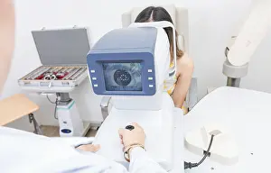 Medical Equipment Prints: Optometrist using refractometer with patient