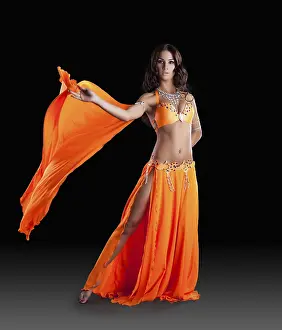 Young Woman Dance Prints: Oriental dancer in studio on dark background