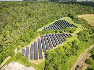 Photovoltaic Module Landscape Prints: Overview of a solar panel landscape surrounded by lush forests and open fields
