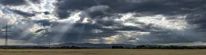 Dramatic Sky Prints: Panorama of a dramatic sky with sunbeams and fields in the foreground