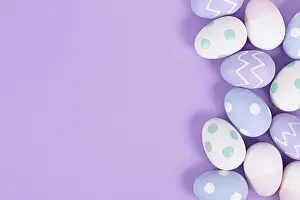 Colorful Still Life Prints: Pastel colored painted easter eggs on side of violet background with copy space