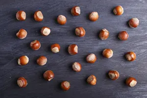 Black Wooden Background Prints: Pattern and texture made from hazelnuts on black wooden background