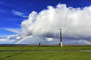 Deserted Irish Beach Prints: Pedestrians on seafront, dramatic cloudy sky with rainbow