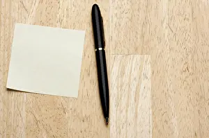 Remembrance Note Pad Prints: Pen and post it notes pad against a wood background