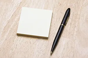 Deserted Office Scene Prints: Pen and post it notes pad against a wood background