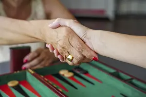 Symbolic Handshake Image Prints: Two people shaking hands over a backgammon board