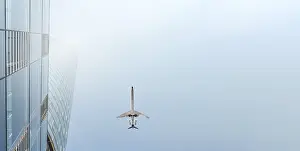 Aviation Industry Images Prints: A plane flies over a skyscraper