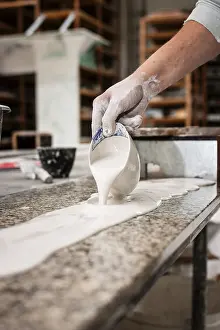 Handicraft Skills Prints: A plasterer pours plaster onto a workbench