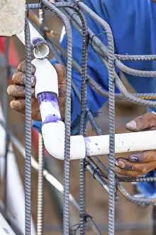 Deserted Construction Area Prints: Plumber installing PVC pipe at construction site