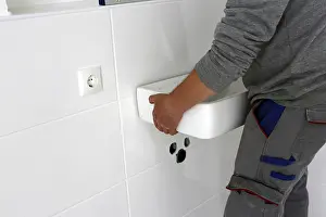 Plumber Installation Prints: Plumber installs a new washbasin