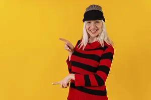 Studio Shot Yellow Background Prints: Pointing to the left in a wool cap