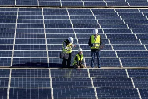 Solar Panel Inspection Prints: Three engineers inspect a large solar panel array together
