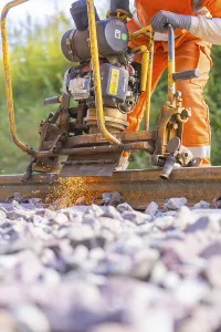 Railway Tracks Prints: Worker using machine for track work