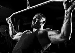 Fitness Training For Men Prints: Professional athlete performs an exercise in the gym