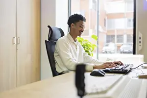 Office Interior Design Prints: A professional works at a computer in a modern office setting