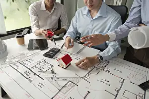 One Person Construction Team Prints: Professionals manage their projects effectively through collaborative discussions about building designs