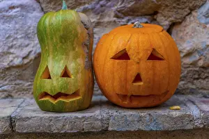 Orange Colored Squash Prints: Two pumpkins with faces carved into them sit on a ledge