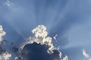 Sun Shining Through Clouds Prints: Rain clouds with sun shining through