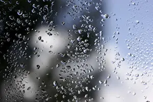 Cloudy Sky With Raindrops Prints: Rain drops on window as the clouds clear behind