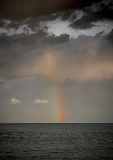 Prismatic Colors In Nature Prints: Rainbow with dark clouds over the sea