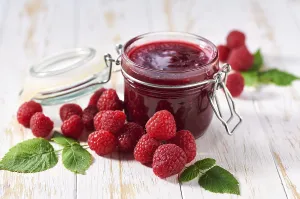 Raspberry Jam Prints: Raspberry jam with fresh berries on a white table