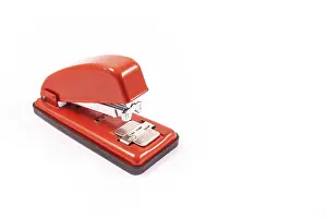Education Symbolic Picture Prints: Detail of a red handheld stapler on a white background