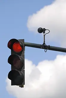 Cloudy Sky Background Prints: Red traffic light with sensor against cloudy sky
