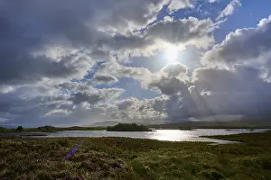 Scottish Highland Lakes Prints: Reflecting lake under a sky with dramatic clouds and sun rays