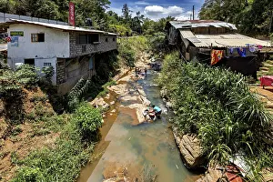 Central Province Travel Photography Prints: A river flows through a village