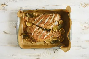 Prints of Two roasted red snapper are placed on baking tray, surrounded by lemon slices and herbs. Dish is golden brown and prepared in oven Snapper Prints: Roasted Red Snapper Print with Lemon and Herbs