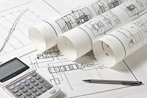 Construction Project Management Prints: Rolled technical drawings and a calculator