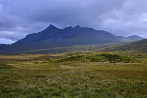 Scottish Nature Photography Prints: Rolling meadows in front of a massive mountain under dark clouds