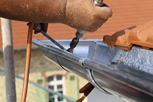 Residential Building Construction Site Prints: Roofer doing tinsmith work on a gutter