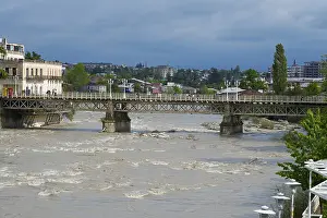 Prints of A rustic bridge across a river with an urban backdrop under cloudy sky, White Bridge over the Rioni River, Kutaisi, Imereti Region, Georgia Kutaisi Prints: White Bridge over Rioni River, Kutaisi, Georgia Print
