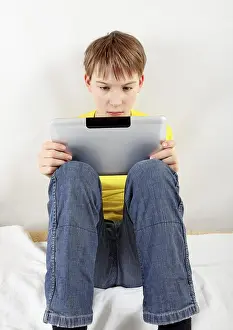 Isolated Child On White Background Prints: Sad Kid with Tablet Computer on the White Background