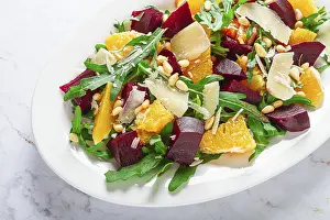 White Plate With Striped Napkin Prints: A salad made with chunks of beet