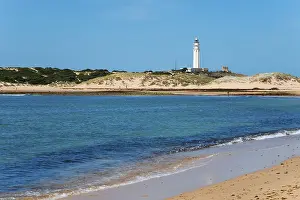 Spanish Coastline Images Prints: Sandy beach beach with lighthouse in the background