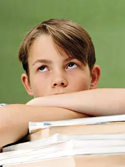 Schoolboy Portrait Prints: Schoolboy in front of a school blackboard with a stack of books