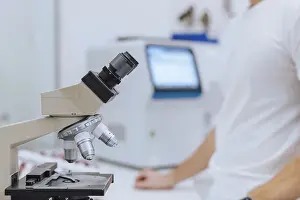 Microscope Analysis Prints: A scientist in a white shirt analyzes samples through a microscope in a modern laboratory setting
